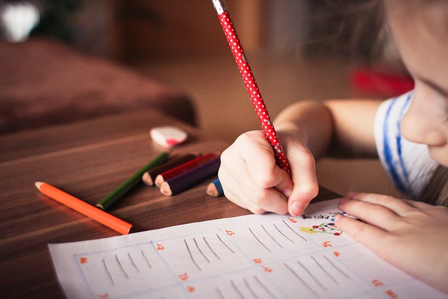 Figura de un niño concentrado, resalta el papely lápiz